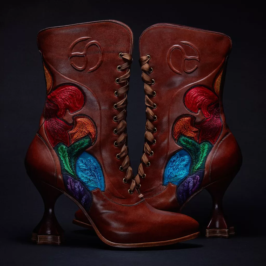 Brown lace-up boots with colourful floral embroidery and sculpted heels.
