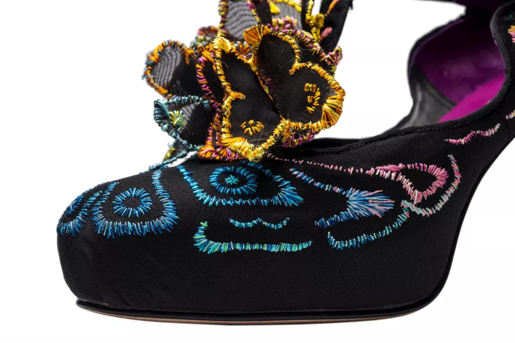 A high platform, T-bar court shoe in black suede. Filled with exquisite representations of butterfly shapes and wings, in black silk crepe with silk hand embroidery. Here you can the butterfly’s clustered at the base of the T-bar and working up and through the entire shoe.