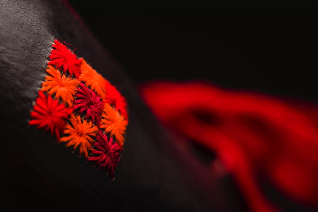 The Folk high vamp court shoe is folk inspired. with a Louis heel featuring multiple leather stacks. The laces are a Vintage silk French ribbon in a striking red. Hand stitched details of this same hue are featured throughout the upper, which is a Veg tanned leather.