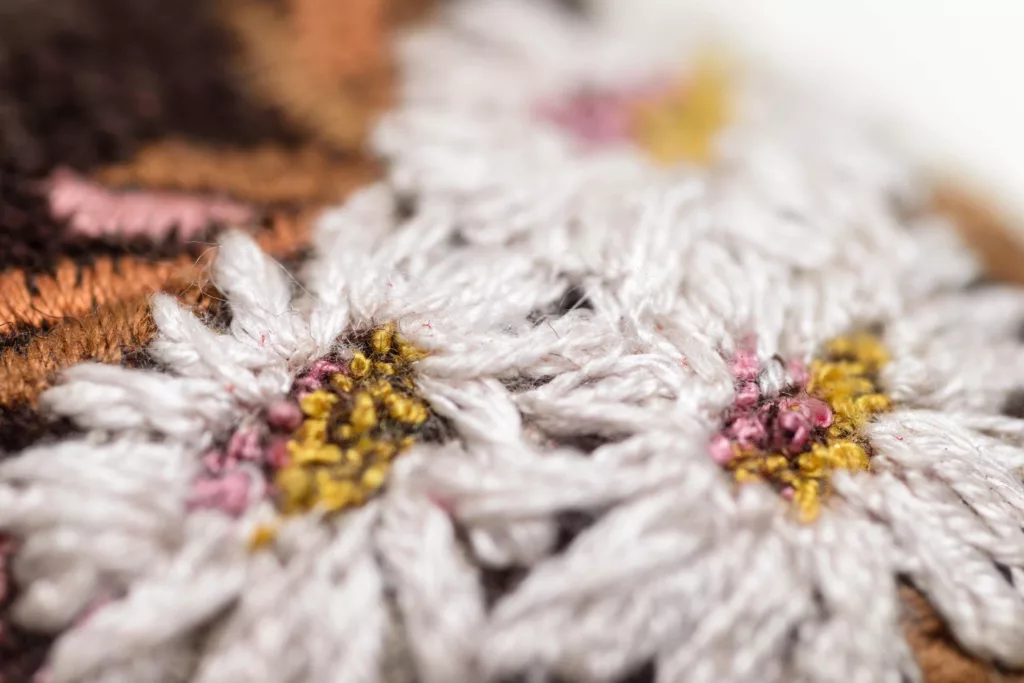 Close up of wonderful floral embroidery in white, pinks and golden tones