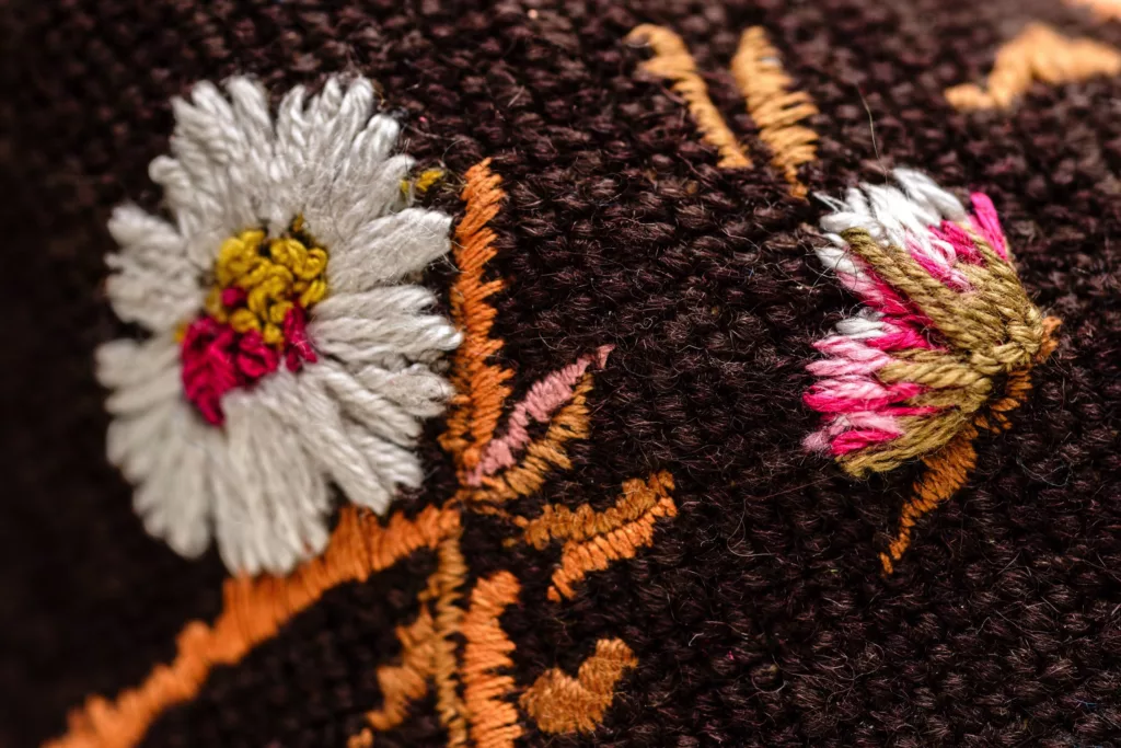 Close up of wonderful floral embroidery in white, pinks and golden tones