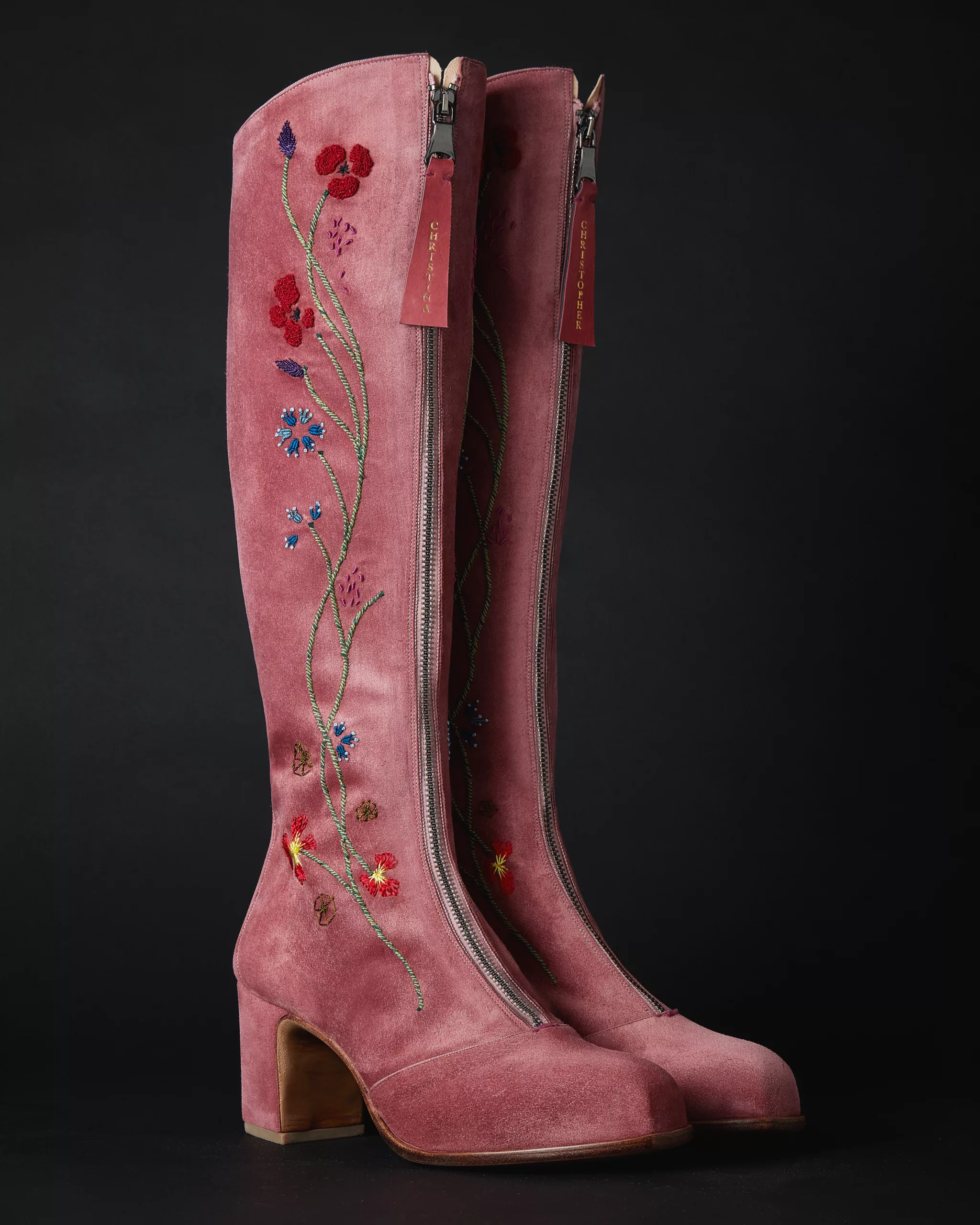 Pair of black ankle boots shown from behind, with small gold accents at the heels.